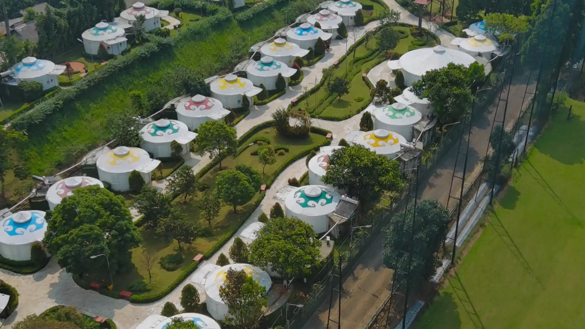 Deretan tenda glamping unik berbentuk bulat di The Highland Park Resort Bogor yang dikelilingi taman hijau dan pepohonan rindang.